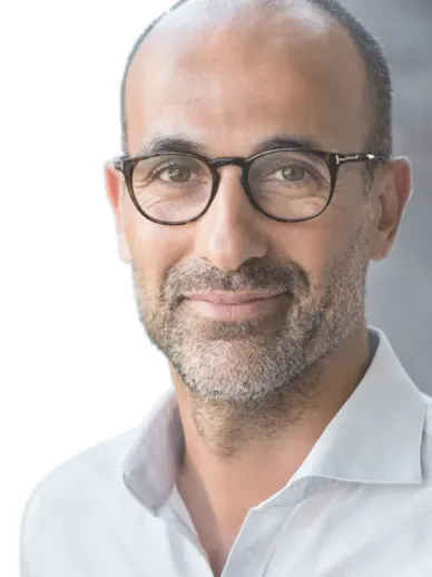 Retrato de un hombre de mediana edad con gafas, barba corta y entradas